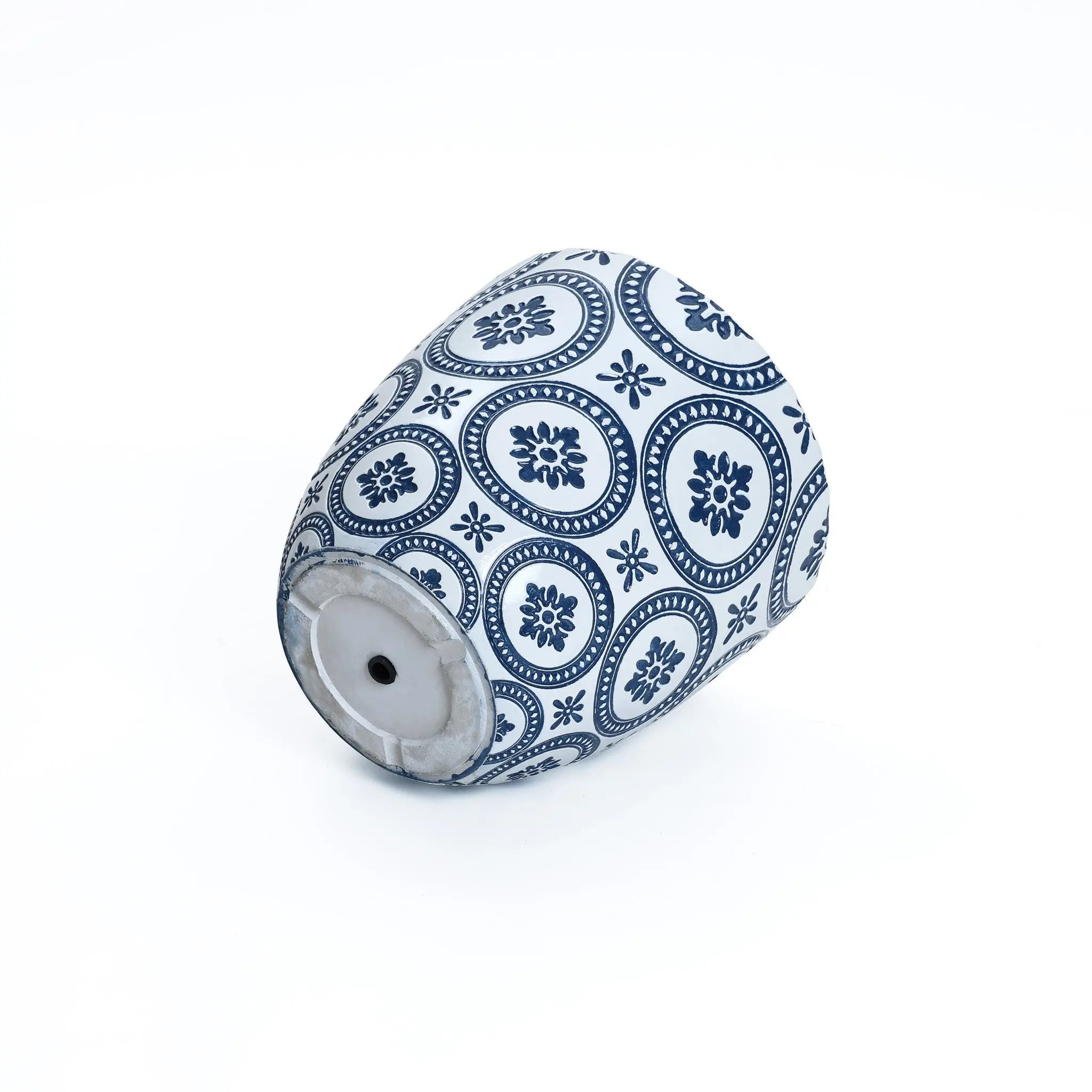 A blue and white pottery piece made of durable MgO material, featuring floral and geometric patterns, rests tilted on its side against a plain background.