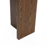 Close-up of a console table boasting a rectangular leg and minimalist design, showcasing its natural wood grain pattern against a white background.