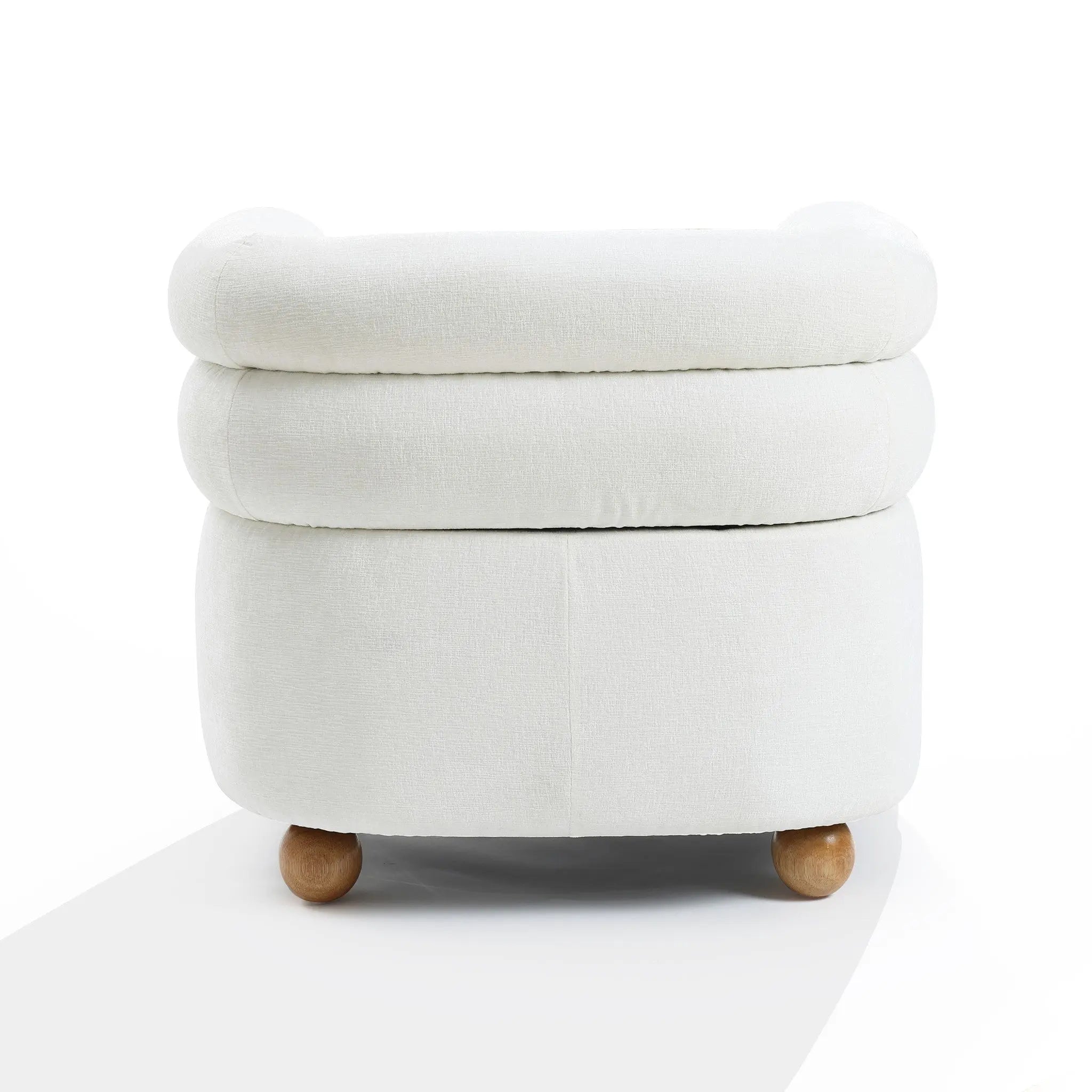 A round, white ottoman with a plush top and wooden ball legs exudes modern charm. Its soft fabric is perfect against a plain background, blending seamlessly with the Tia ivory barrel accent chair by LuxenHome.