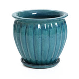 A glossy ceramic decorative planter with vertical ridges, finished in a navy blue glaze, comes complete with drainage holes and a matching saucer underneath.