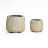 Two textured, ribbed texture planters in light brown finish, cylindrical in shape, come in different sizes on a white background. Perfect for both indoor and outdoor settings, these planters beautifully blend style and functionality.