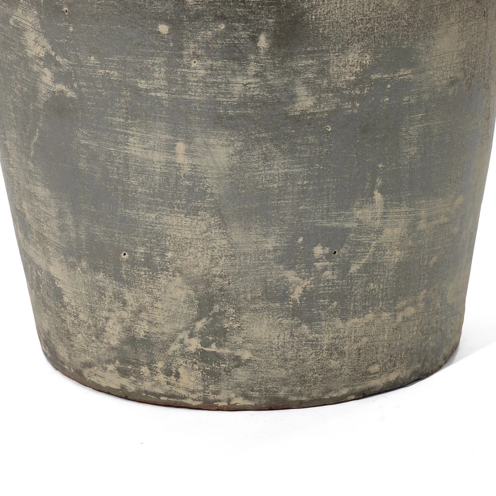 Close-up of a large Fou antique terracotta vase by LuxenHome with a textured, rustic surface. The handcrafted vase mixes gray and beige tones for an aged, natural look. Its bottom edge shows against a white background.