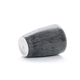A LuxenHome Sea Gray Ripples glazed ceramic planter, 17 tall, features a textured dark gray design with subtle black-and-white vertical stripes and horizontal lines. It rests on a smooth, rounded base against a plain white background, completing its elegant look.