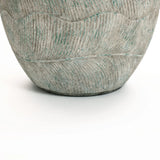 A close-up of the Rustic Multi-Color Cement 15.4-Inch Round Planter by LuxenHome showcases its textured ceramic design with wavy patterns and a subtle greenish hue, reminiscent of rustic charm, against a plain white background.