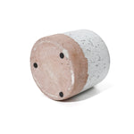 Gray-speckled cylindrical stool or side table with a light brown base, reminiscent of a stoneware vase, viewed from an angle.