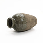 A large, rustic clay vase exudes rustic charm with its narrow opening and textured, dark brown outer surface, gracefully laying on its side against a plain white background—perfect for showcasing elegant floral arrangements.