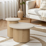 Wooden side table in a living room setting with a sofa and decorative vase.