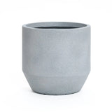 A gray, cylindrical concrete planter with a smooth matte finish sits on a white background, embodying modern minimalist design. Its weather resistance makes it ideal for both indoor and outdoor decor.