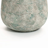 Close-up of the textured surface of the Rustic Multi-Color Cement 18.3-Inch Round Planter by LuxenHome. It features a wavy pattern with green accents on its gray surface, offering an artistic look against a plain white background.