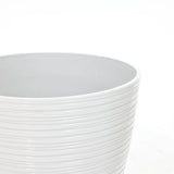 Close-up view of a white ribbed planter, perfect for decorative indoor and outdoor use against a plain background.