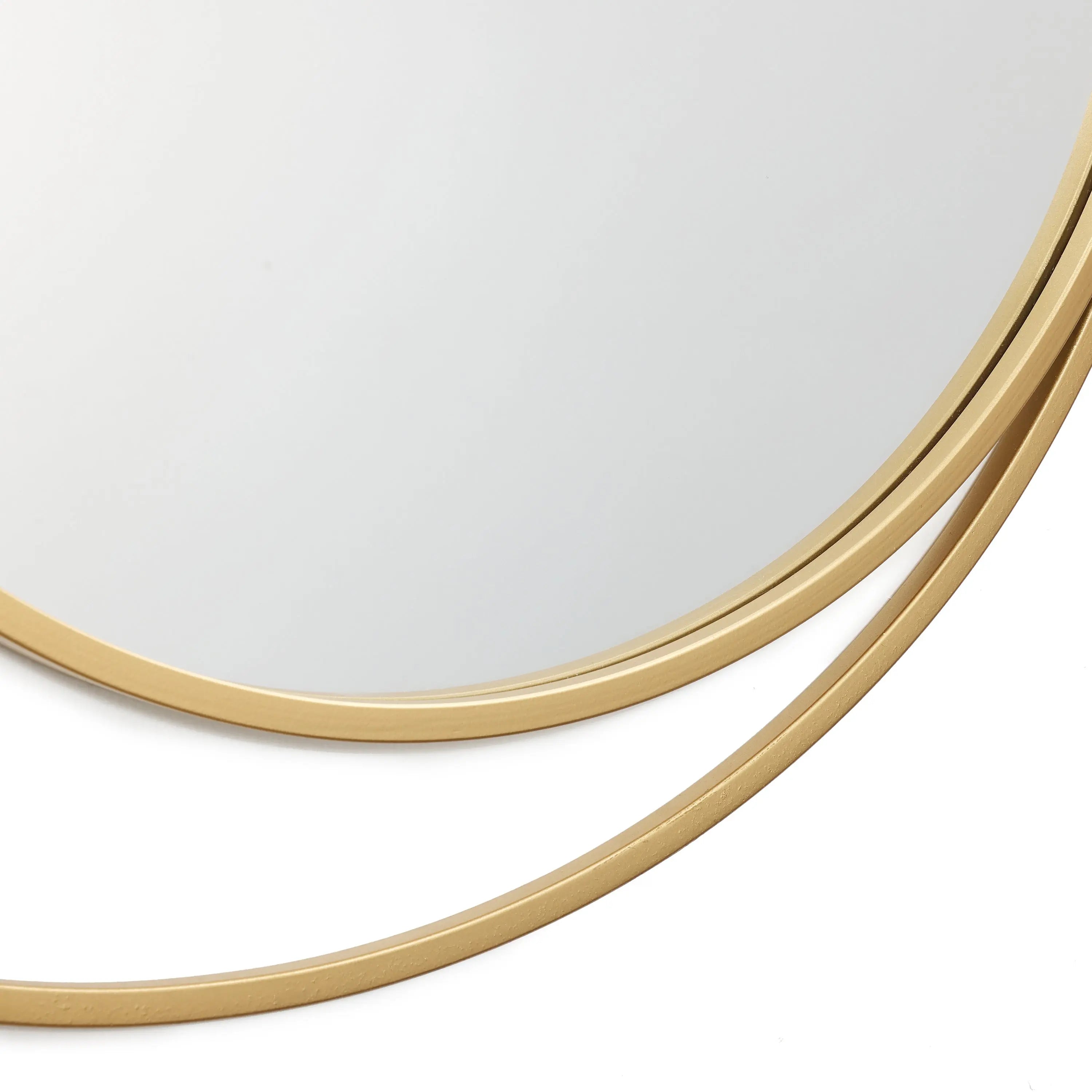 A close-up of a wall mirror showcases its thin, golden frame, exuding modern elegance. The edge of this stylish accessory highlights part of the reflective surface.