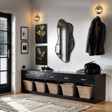 The hallway features an asymmetrical mirror with a sleek black frame, perfectly complementing the wall art and coat hanging. Modern minimalism shines through with a bench that holds wicker baskets for storage, where shoes and a bag rest neatly.
