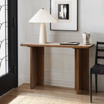 A mid-century modern wooden console table with a white lamp and a marbled cup sits in the hallway. Above it, a framed abstract art piece adorns the wall, reflecting minimalist design. A black chair is partially visible beside the table.