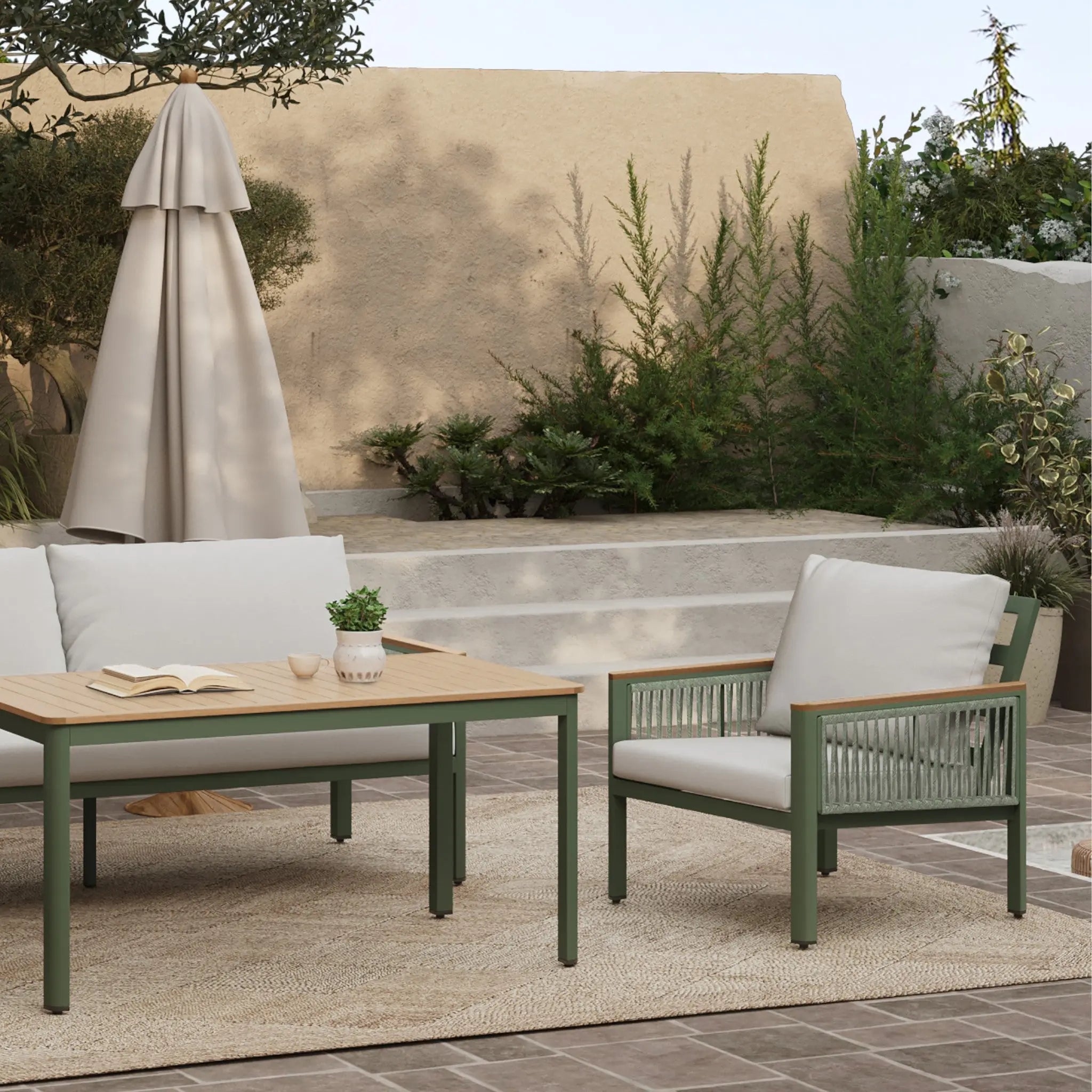 Outdoor patio set with a durable aluminum alloy frame, wooden table, plush-cushioned loveseat sofa, and chair on a rug. Stone steps and greenery are in the background.