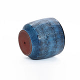 A high-quality ceramic Ocean blue glazed round planter by LuxenHome lies on its side, revealing a reddish-brown base. Its glossy finish subtly reflects light against a plain white background. Size: 13.98 h.