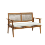 Crafted from FSC-certified Acacia wood, this wooden bench boasts a slatted backrest and woven accents, complemented by a white cushion on the seat. Perfect for outdoor furniture enthusiasts who appreciate minimalist design.