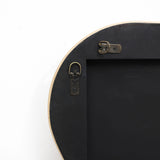 Close-up of the back of a round picture frame crafted from cork wood, featuring two metal brackets and a hanging hook against a white background.