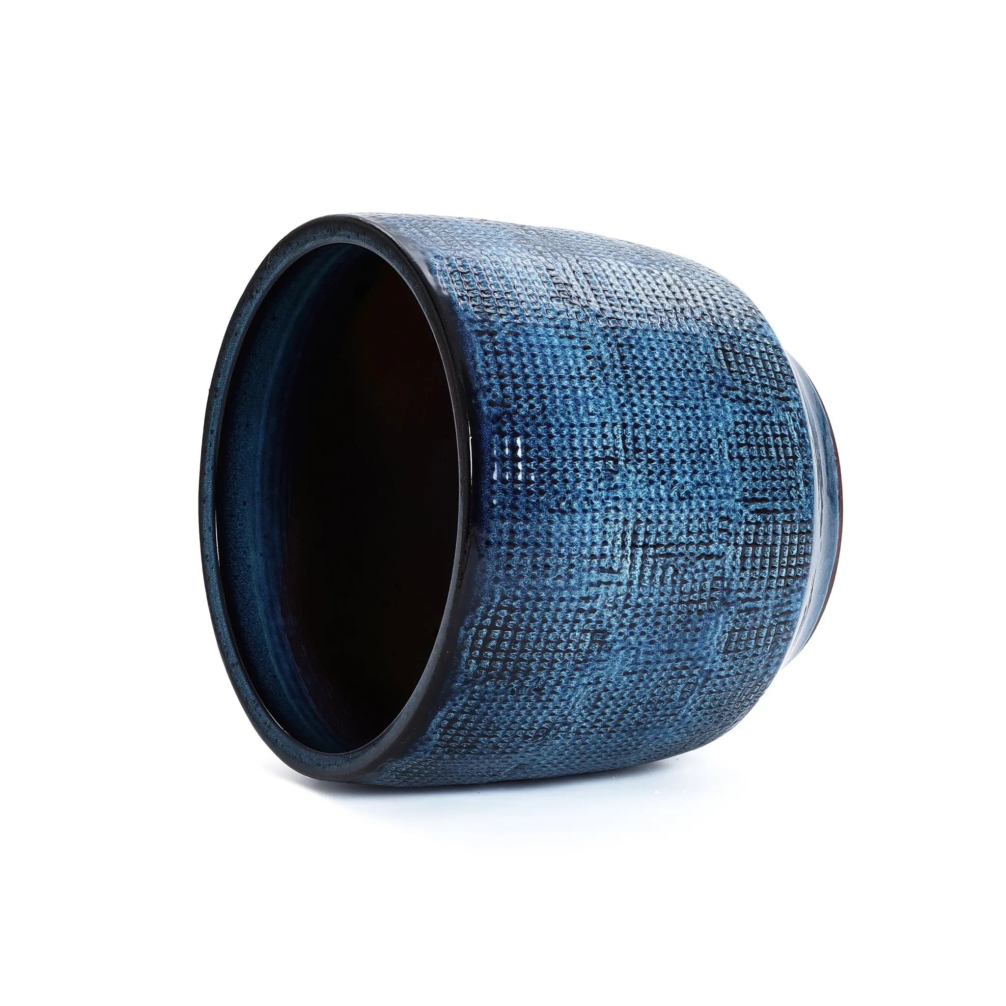 The LuxenHome Ocean blue glazed round ceramic planter, 13.98 h, features a textured grid pattern on its artistic dark blue exterior and a contrasting dark interior, enhancing its modern design.
