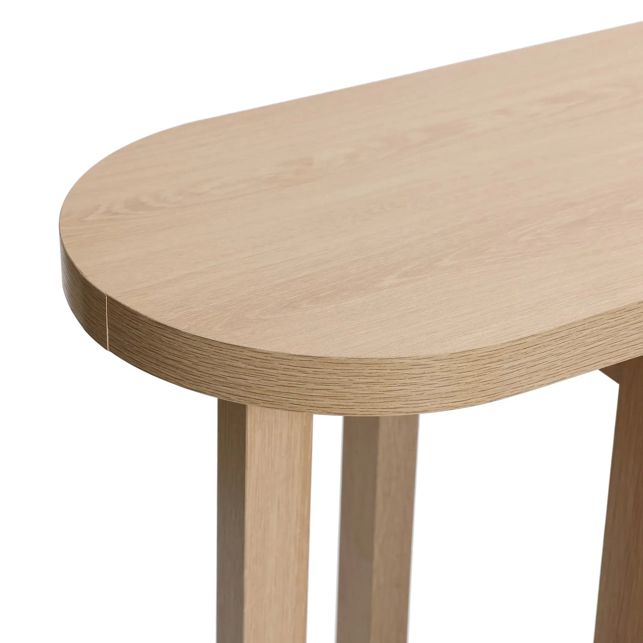 Close-up of the LuxenHome Lorean console table with a natural finish, highlighting its smooth oval-edged surface and grain pattern. The four legs in the bottom right corner accentuate its minimalist design.