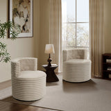 A cozy living room showcases two LuxenHome Brie camel swivel barrel accent chairs, a dark wooden side table with a lamp, and beige curtains. A large window overlooks a blurred outdoor scene. The space is adorned with a plant and abstract artwork.