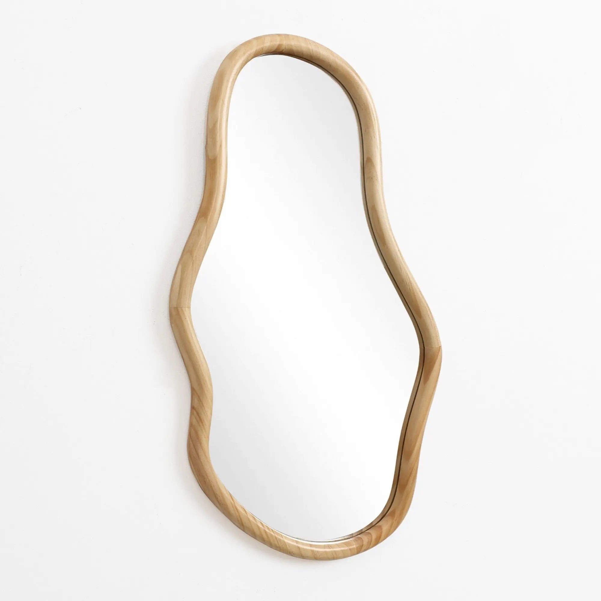 Irregular oval-shaped mirror with a curved wooden frame, crafted from natural pine wood, making a decorative statement against a plain white background.