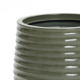 Close-up of a green, ribbed ceramic planter with a glossy finish. The view captures the upper edge, highlighting the textured pattern, perfect for both indoor and outdoor environments.
