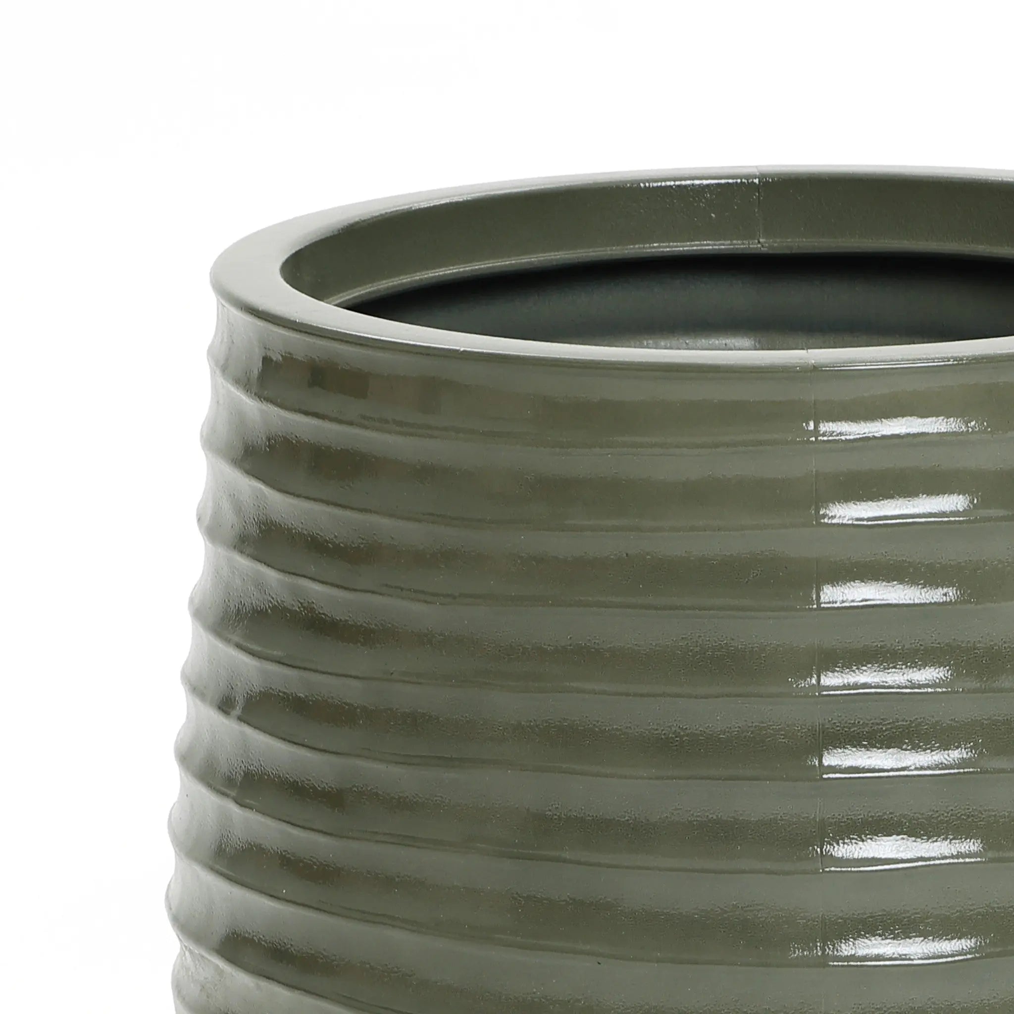 Close-up of a green, ribbed ceramic planter with a glossy finish. The view captures the upper edge, highlighting the textured pattern, perfect for both indoor and outdoor environments.