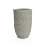 Tall cement planter with a textured, crisscross pattern. Gray in color, cylindrical shape, and smooth opening at the top. Perfect for a modern minimalist design.