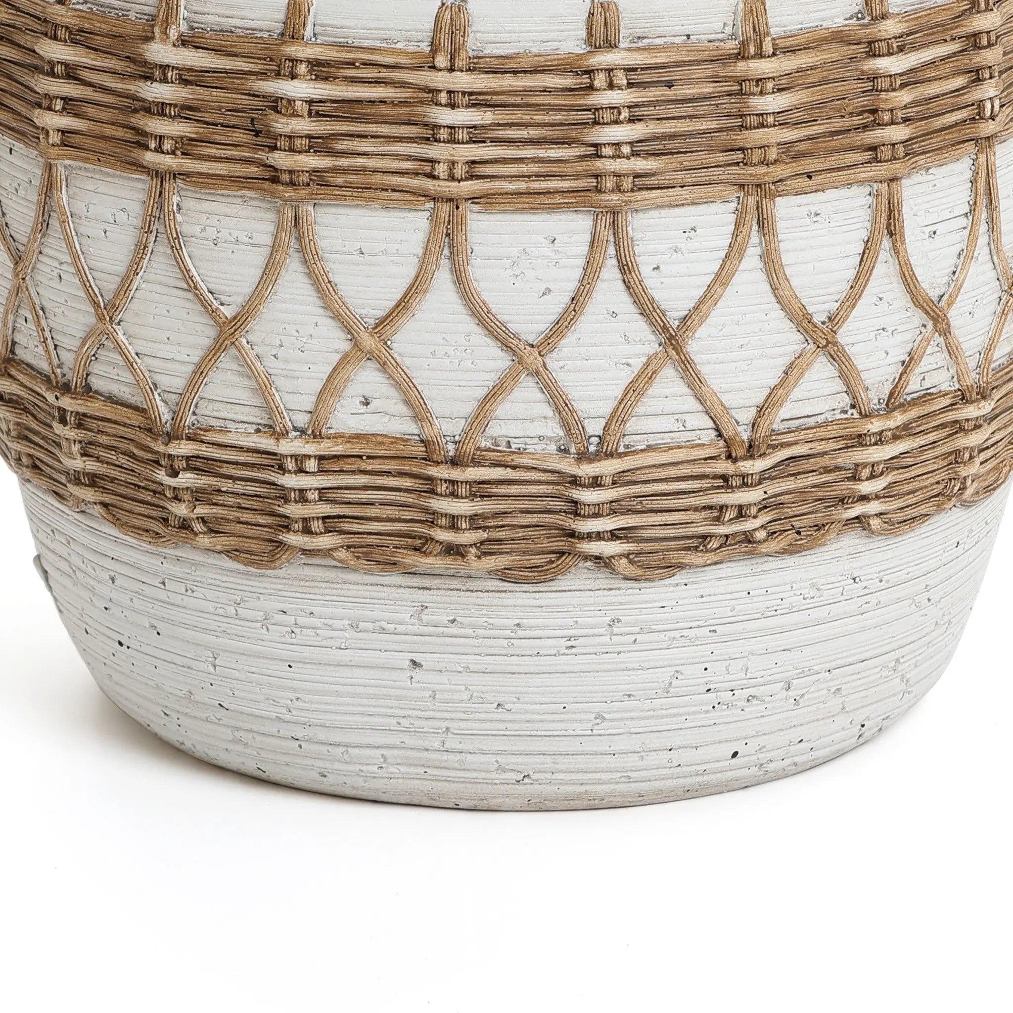 Close-up of a textured ceramic planter with woven rattan detailing in a diamond pattern, evoking a bohemian style. The pot is light grey with natural brown accents, perfectly blending traditional craftsmanship with modern aesthetics.