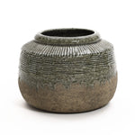 The LuxenHome Rustic Brown Stoneware Bowl Vase showcases a rounded silhouette with a green glazed, textured top and natural brown base. The glaze elegantly drips onto the base, offering a charming stoneware terracotta appeal and adding a rustic, handmade element to your decor.