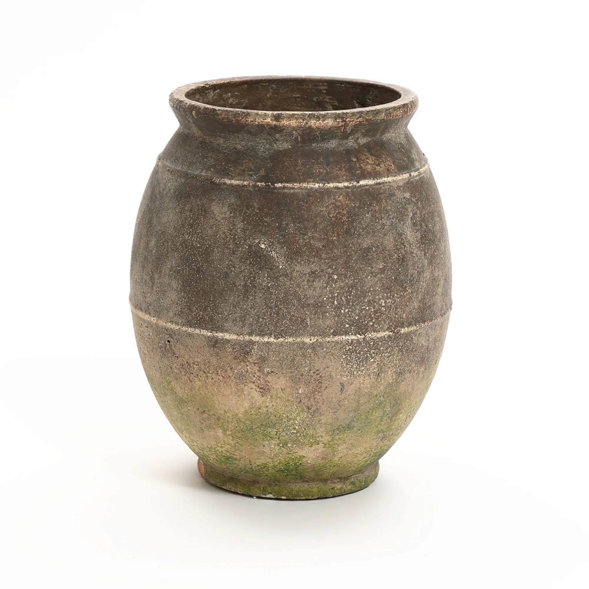 A large, weathered terracotta urn vase with a round body and wide opening against a plain white background. It features two horizontal grooves and a slightly greenish tinge, offering rustic charm that complements both indoor and outdoor settings.