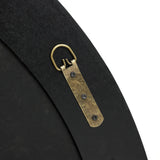 Close-up of a brass hanger attached to a flat, dark surface with three screws, featuring a round loop at the top. This elegant addition is perfect for holding a round mirror or accentuating furniture with poplar burl veneer and a burlywood MDF frame.