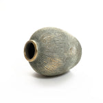 The LuxenHome Rustic gold and brown terracotta bud vase, 8.7 h, boasts a textured oval shape with a narrow opening and subtle ribbed pattern. Its aged, antique distressed look in muted earthy tones complements any home decor against a plain white background.