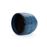 An Ocean blue glazed round ceramic planter by LuxenHome, featuring a speckled gradient with a dark interior and handcrafted design, lies on its side against a plain white background.