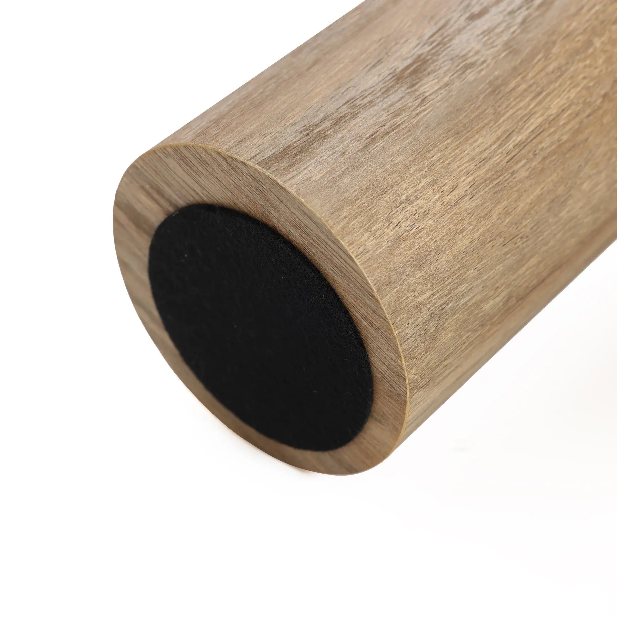 Close-up of a wooden cylindrical object with a black rubber end, resembling the sleek design of an oak finish side table.