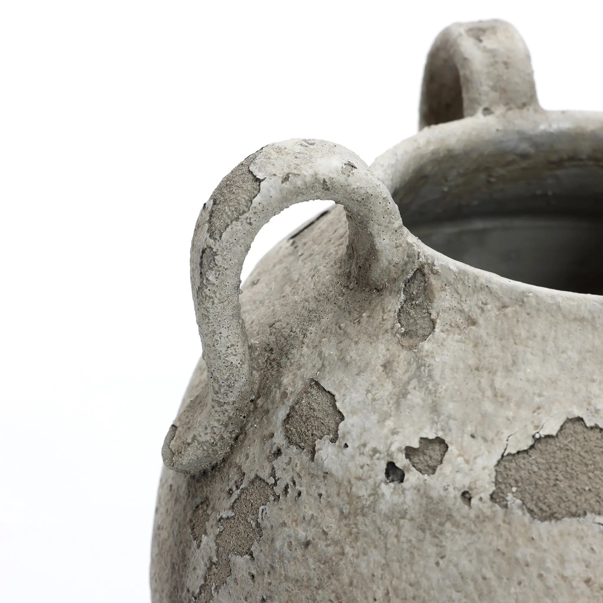 A close-up of the aged, textured LuxenHome rustic gray and white terracotta vase with handles, 11 h, highlights its curved handle and upper rim. It showcases weathered details against a plain background, blending handcrafted charm with contemporary elegance.