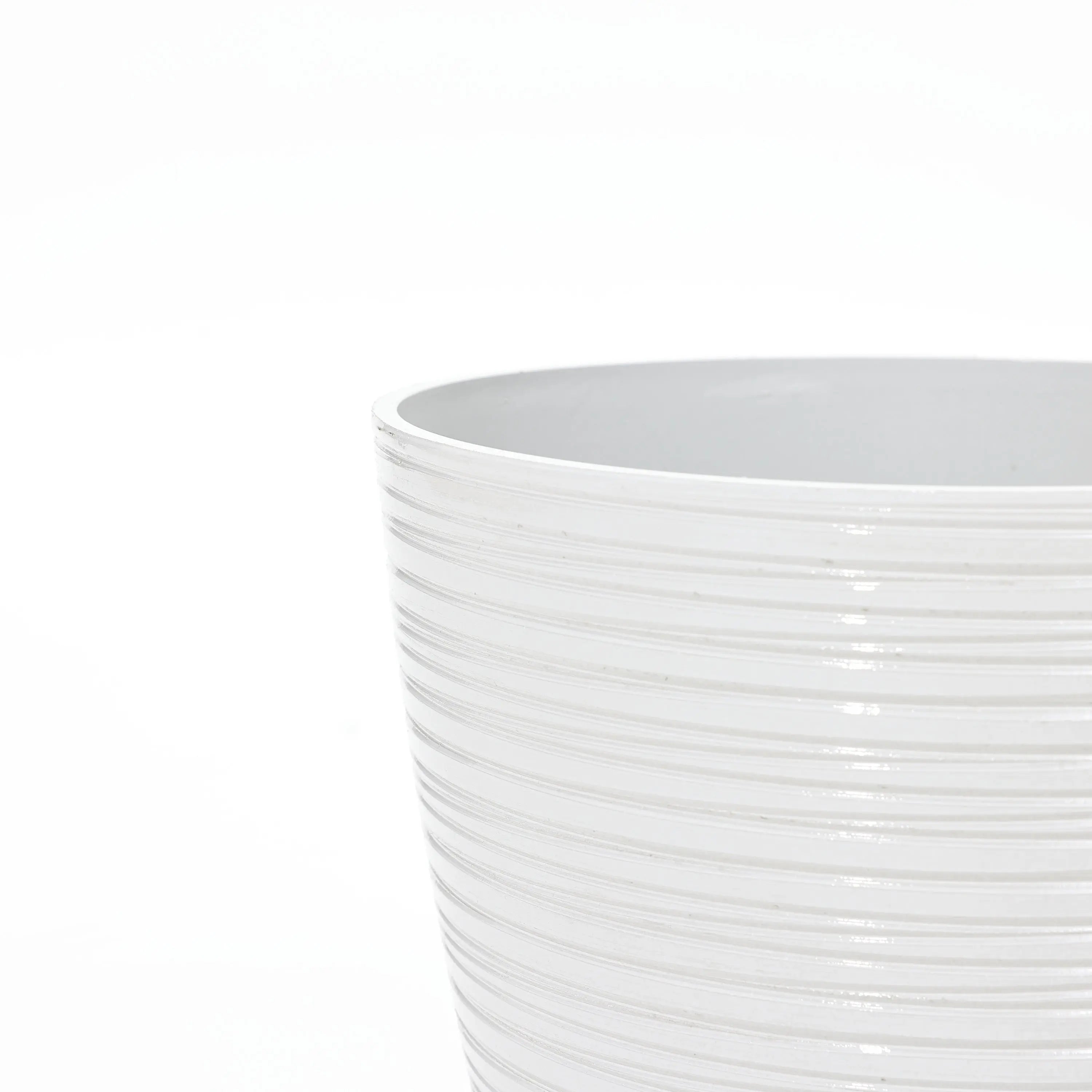 Close-up of the textured upper edge of a white ceramic decorative planter, perfect for indoor and outdoor use, against a plain background.