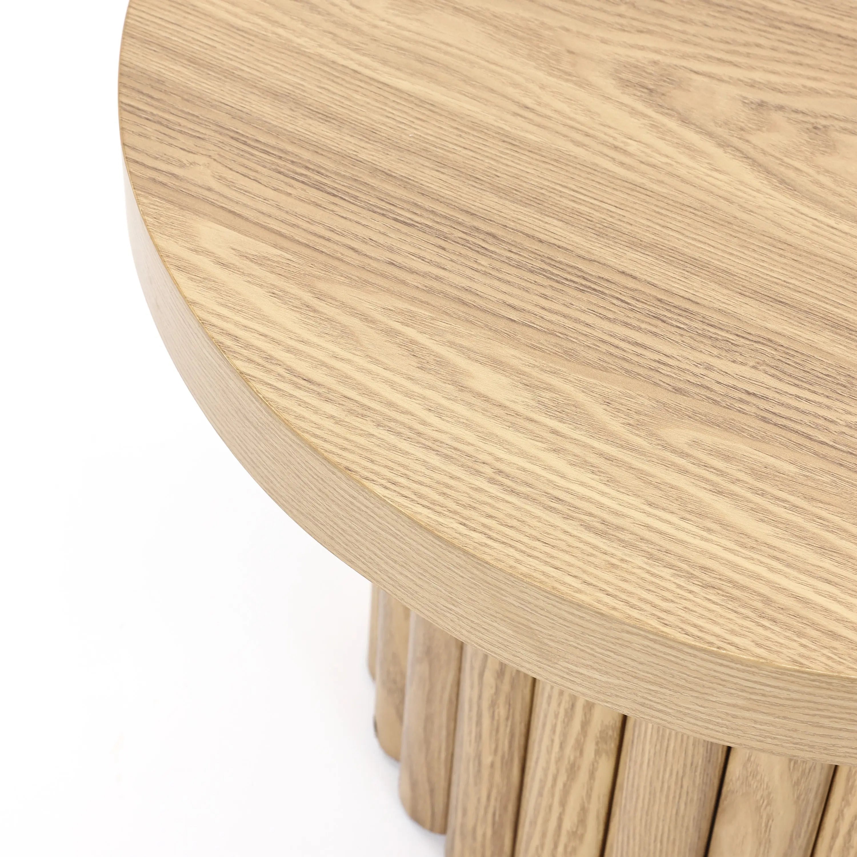 A round wooden coffee table with a smooth, light wood grain surface and vertical slatted base, featuring an elegant oak finish that complements its modern design.