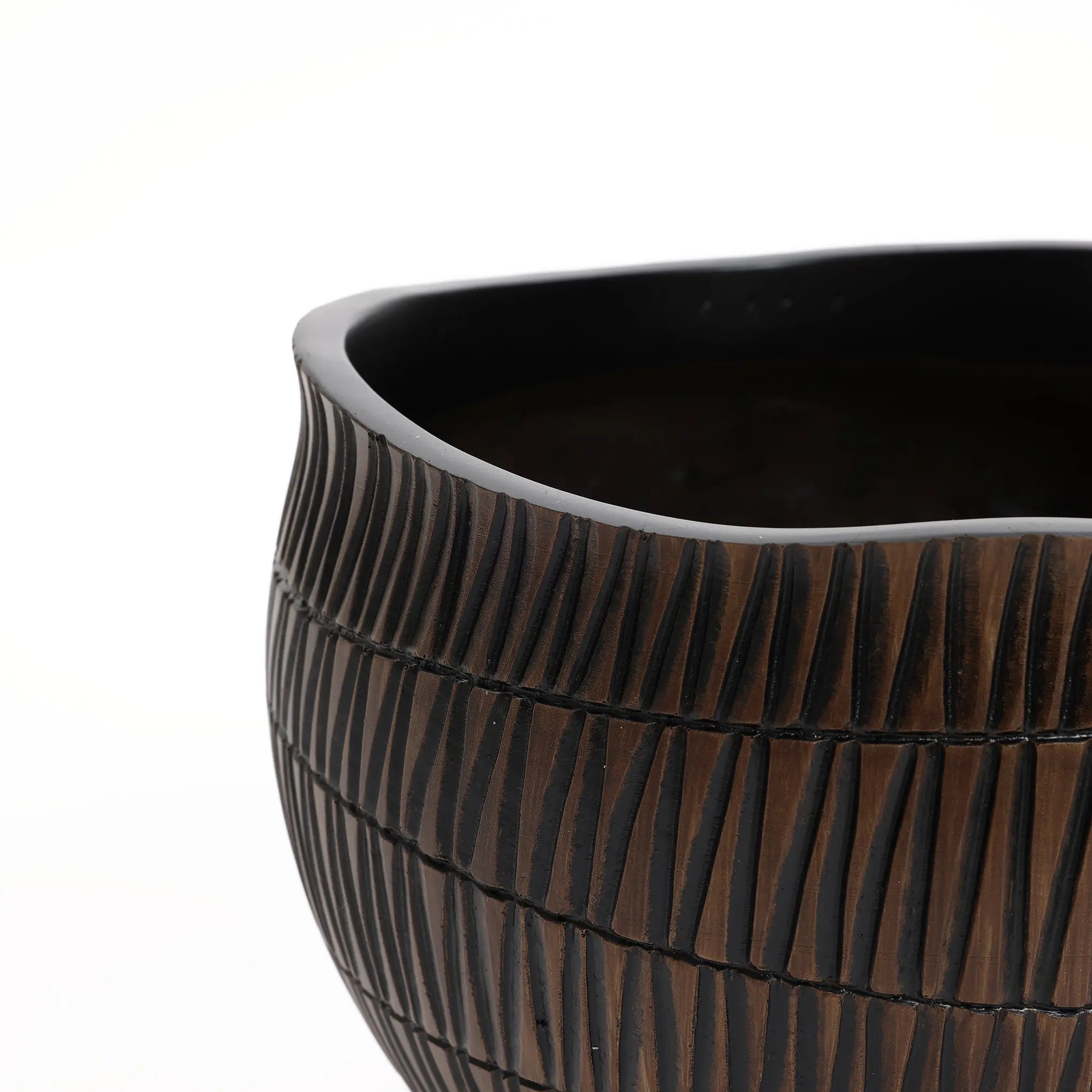 Close-up of a LuxenHome dark brown textured resin round planter, small. It features horizontal grooves and an irregular rim, echoing geometric planter design. The plain light background highlights the detailed craftsmanship.