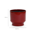 The LuxenHome burgundy red glazed round ceramic planter, measuring 11.61 tall and 12.4 in diameter, features a vertical stripe design with subtle ridges and a drainage hole for plant health, set against a plain white background.