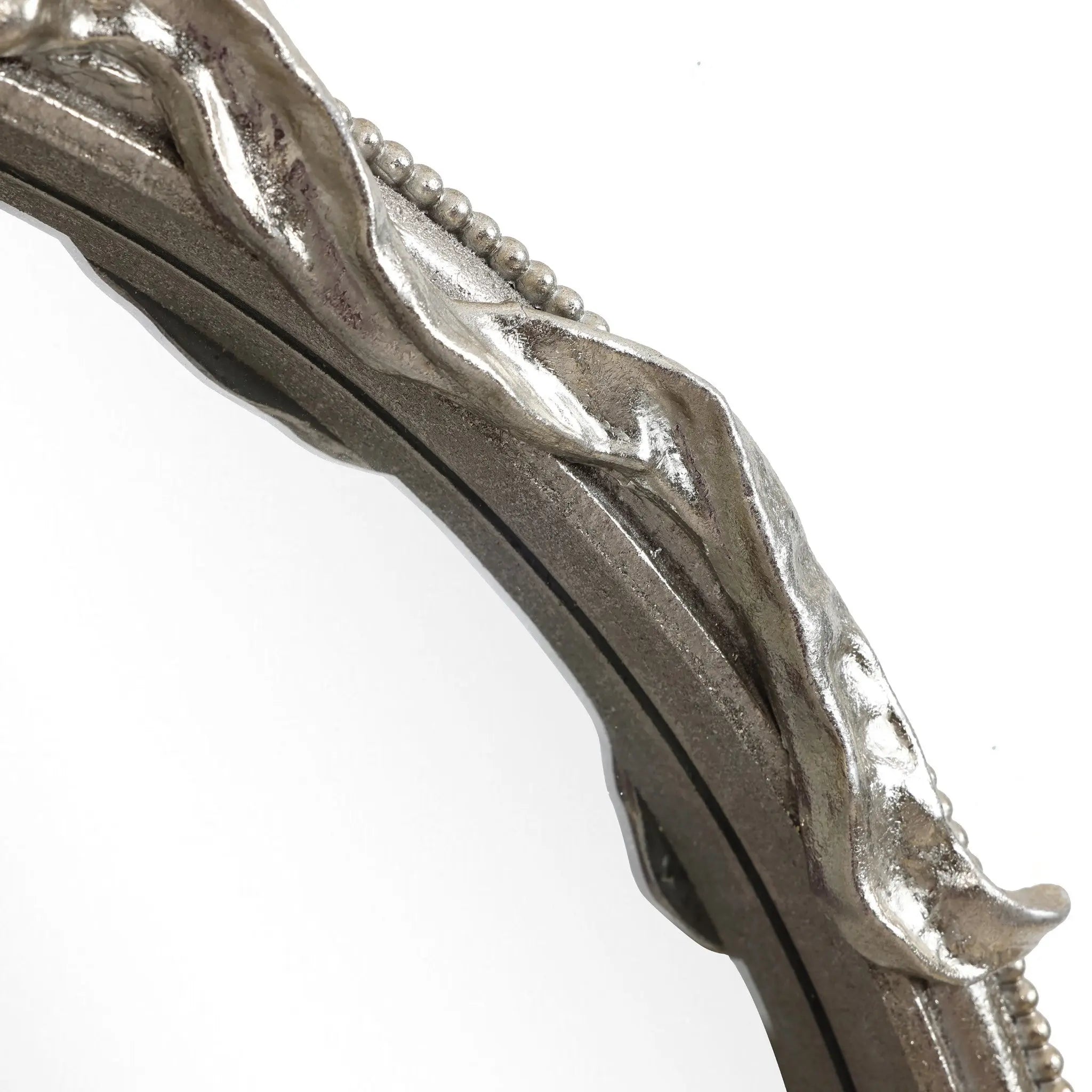 Close-up of a circular metallic frame with a wavy, textured surface and small bead-like details along the edges, echoing the modern romantic style.