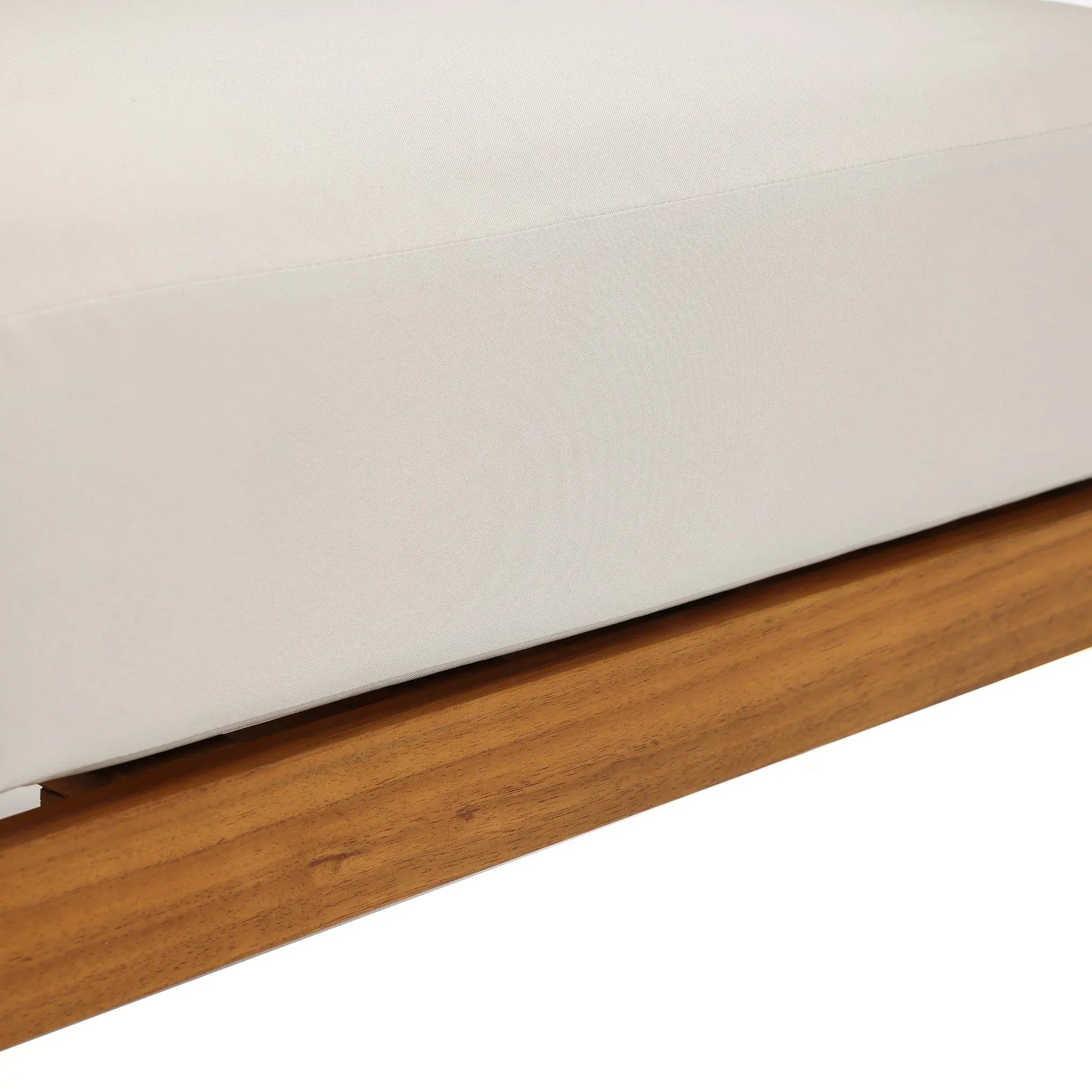 Close-up of a white upholstered cushion resting on an Outdoor Acacia Wood frame, likely part of Club-Style Patio Furniture or a Rope Sides Loveseat.
