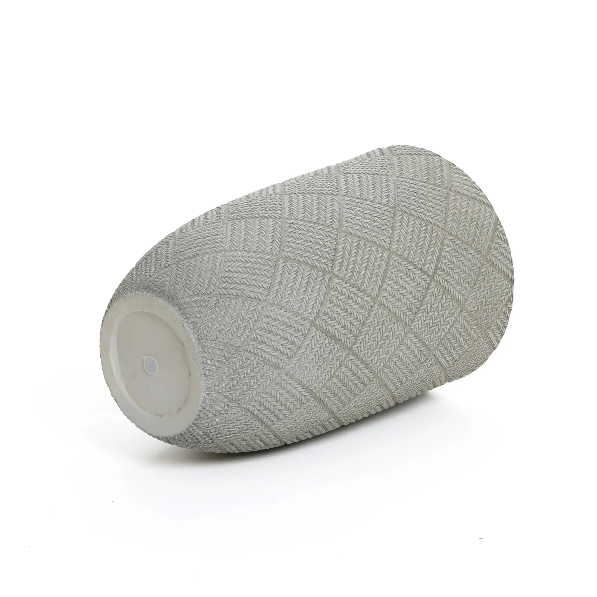Gray cylindrical object with a textured, diamond-patterned surface, reminiscent of modern minimalist design, lies on its side against a white background.