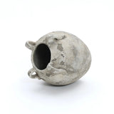 The LuxenHome 11 Rustic gray and white terracotta vase, featuring two handles, lies sideways on a plain white background with a weathered texture and visible patches of wear.