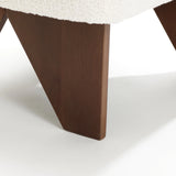 Close-up of the LuxenHome Lorenzo accent chair. It features dark wooden legs with a geometric, mid-century angular design and a cream-colored cushioned top featuring high-density foam, resting gracefully on a smooth white surface.