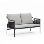 This modern two-seater sofa features gray, removable waterproof cushions and a black metal frame accented with wooden armrests. Designed for versatility, it seamlessly transforms from an indoor piece to part of an outdoor seating set.