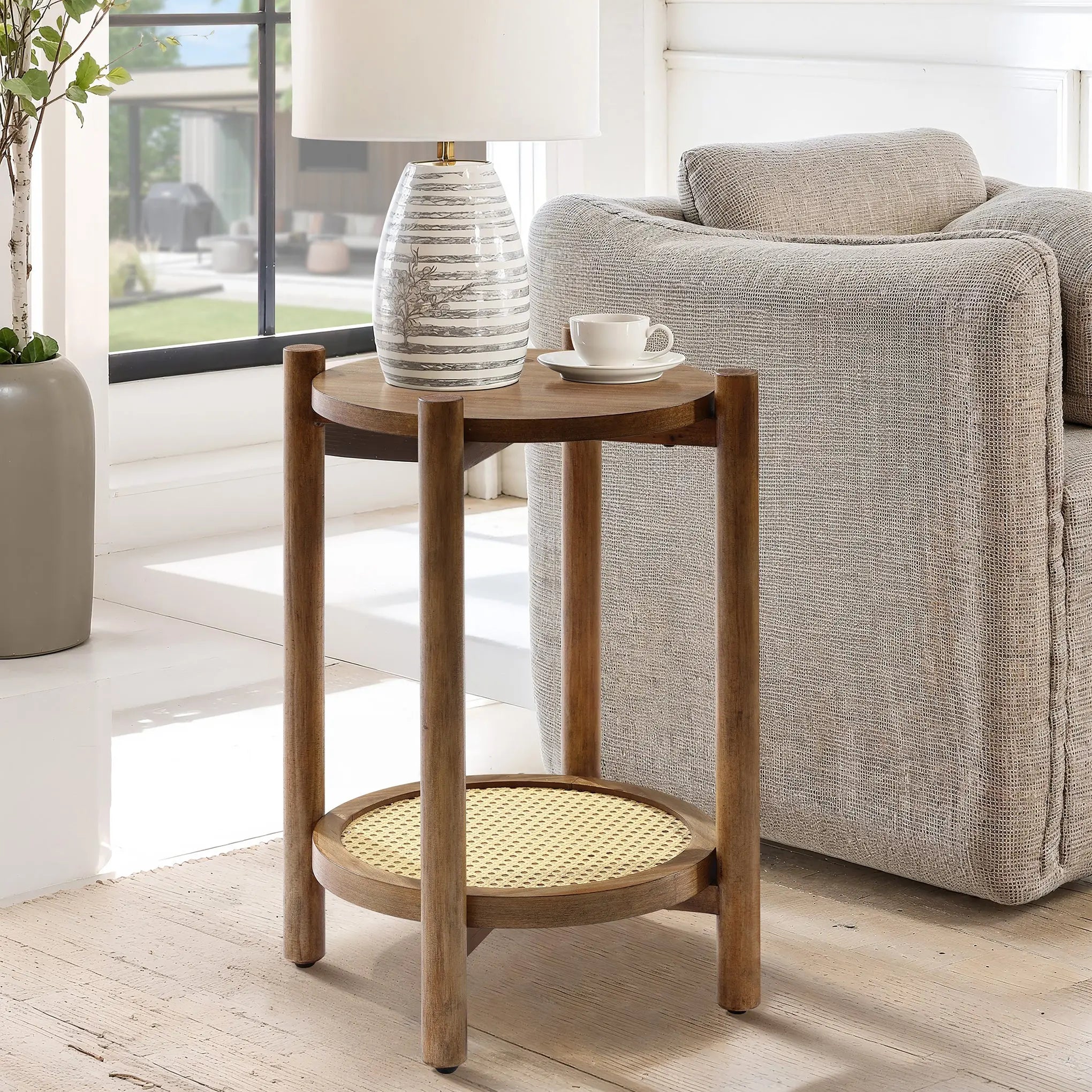 A wooden side table crafted from pine and MDF wood with a chestnut finish features a white striped vase and a cup, perfectly complementing the gray sofa in the bright room.