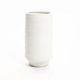 A plain, white terracotta vase stands upright against a white background, showcasing its classic cylindrical form.