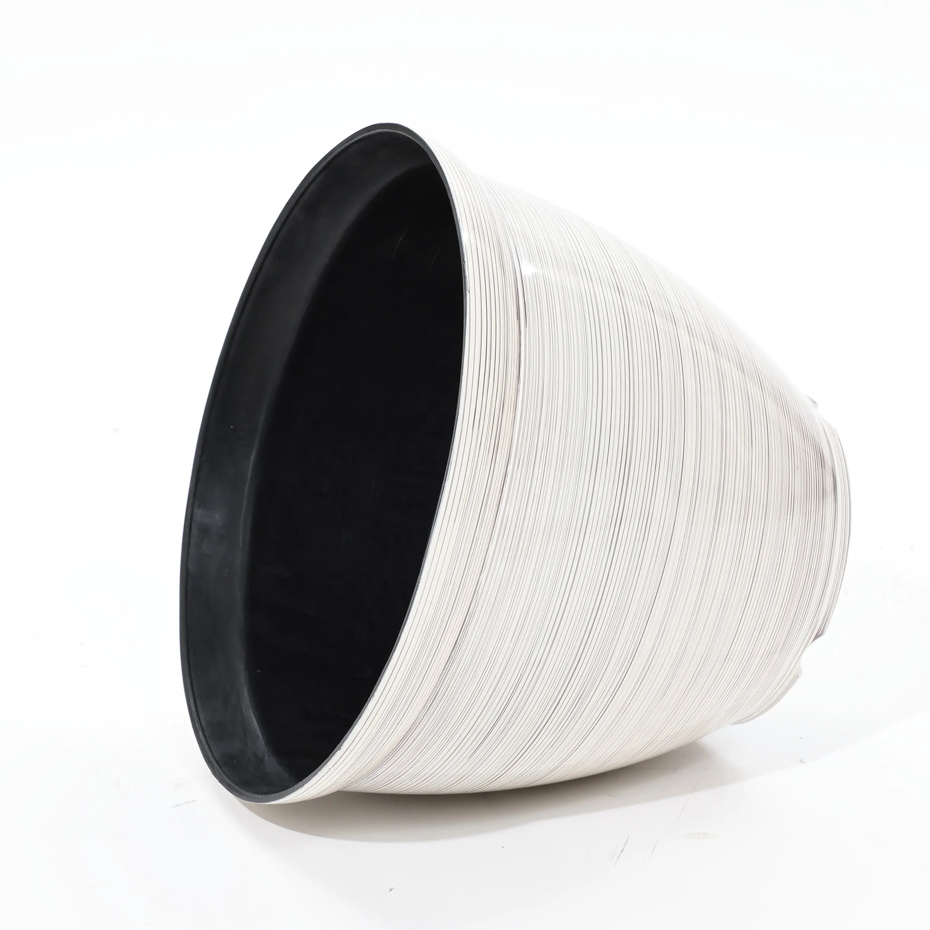 A large, cone-shaped basket with a textured surface, crafted with durable plastic construction, rests on its side against a plain background. This contemporary planter in white and black seamlessly combines modern style with functionality.