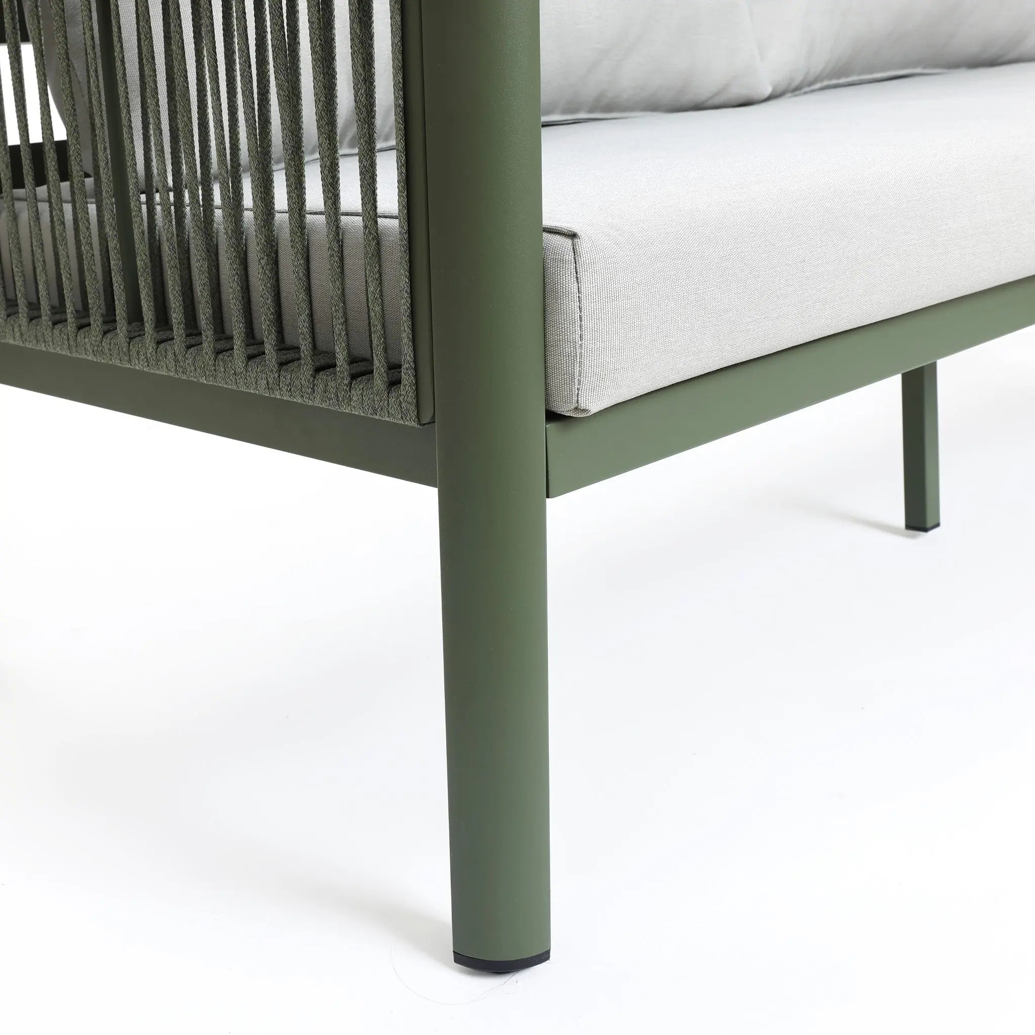 Corner of a green metal outdoor loveseat sofa with plush light gray cushions and rope accents on the armrest, featuring a durable aluminum alloy frame, set against a white background.